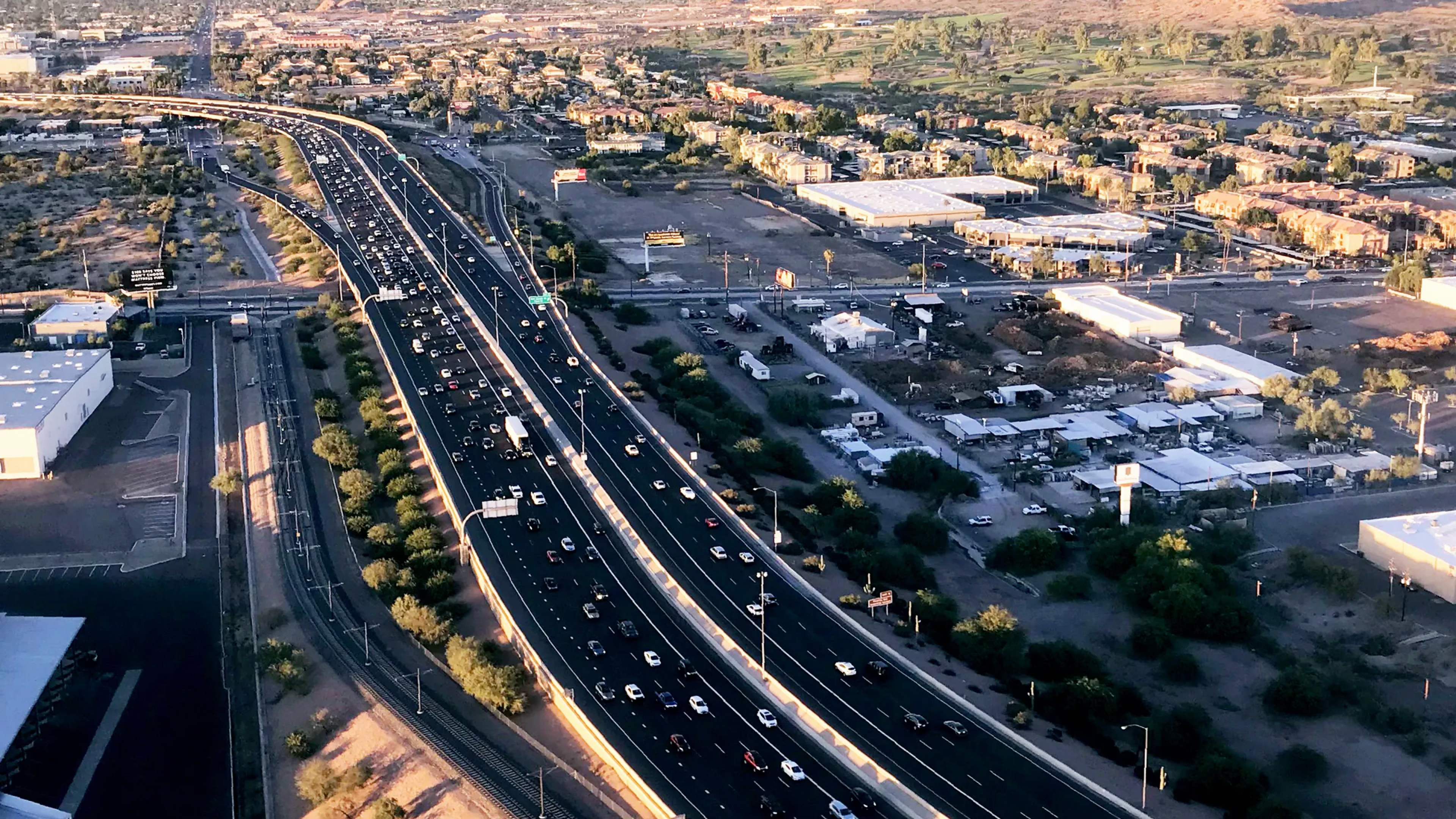 An overhead view of of a freeway cutting through a mainly industrial district in Arizona